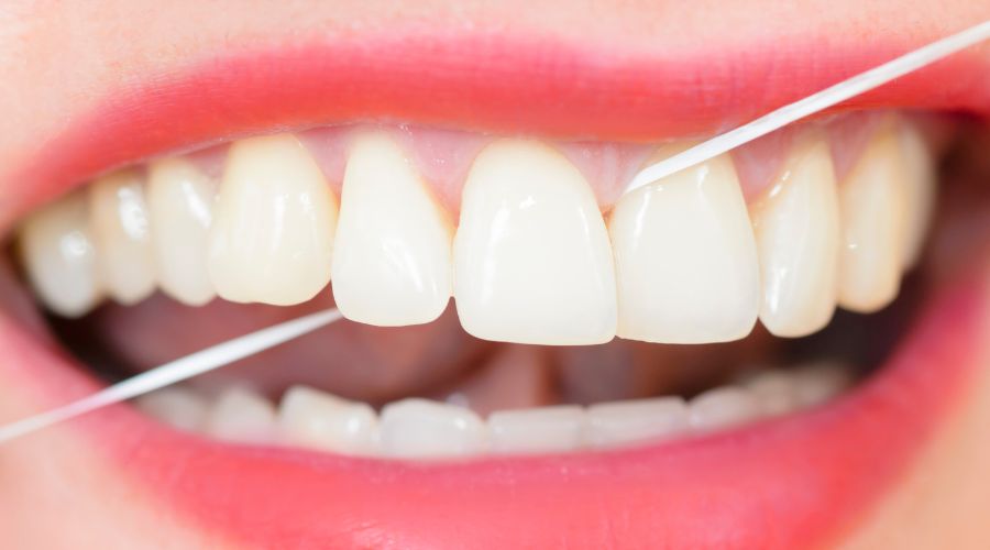 Uso de hilo dental para una correcta higiene bucal
